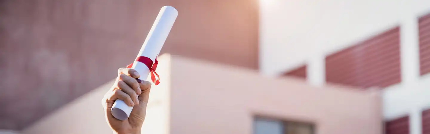 A person holding a degree in the air.